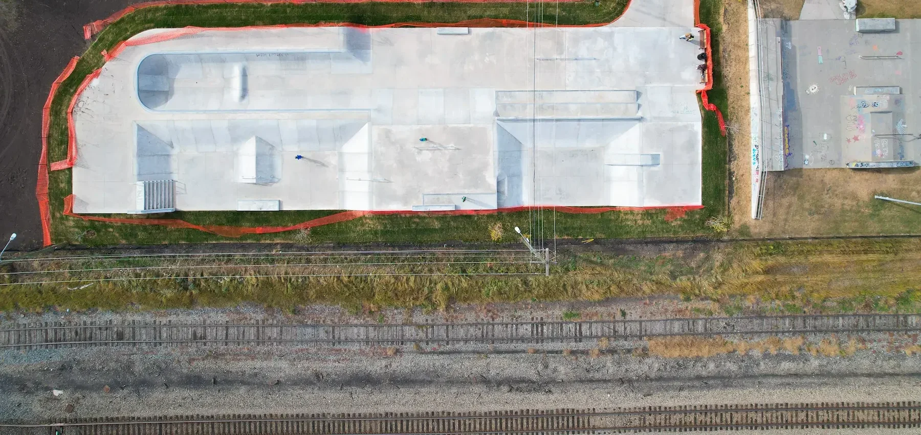 Aerial view of urban park with skatepark, playground, drainage and green spaces