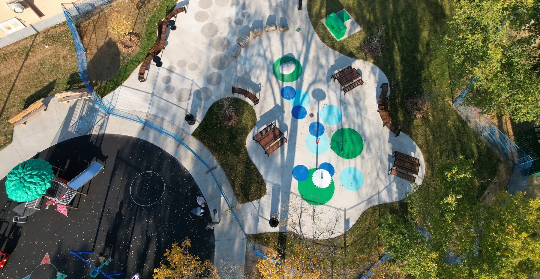 Aerial view of urban park with skatepark, playground, drainage and green spaces