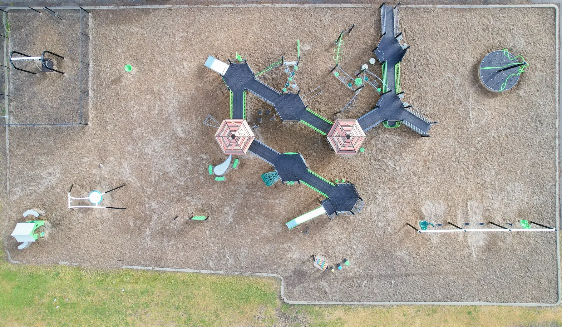 Aerial view of urban park with skatepark, playground, drainage and green spaces